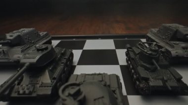 Satranç tahtasındaki oyuncak tanklar. Askeri strateji kavramı.