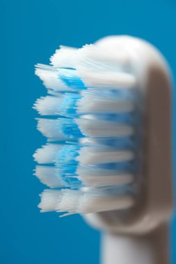 Mavi arka planda elektrikli ultrasonik diş fırçası kılları.