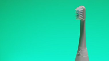 Değişen renk arkaplanında elektirikli ultrasonik diş fırçası.