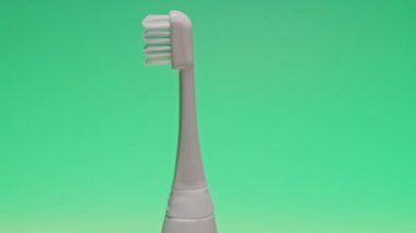 Değişen renk arkaplanında elektirikli ultrasonik diş fırçası.