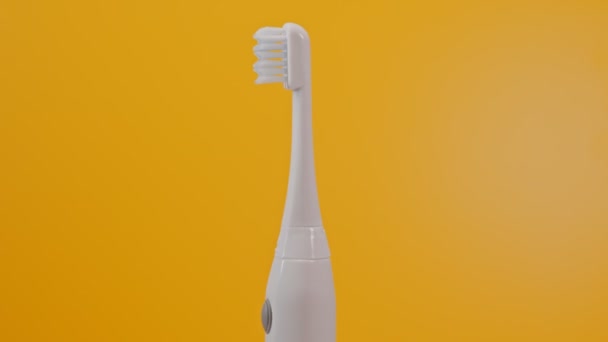 Electric Ultrasonic Toothbrush Yellow Background — стоковое видео