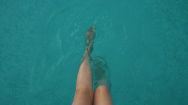 Dişi bacaklar. Havuzun kenarında oturan kadın..