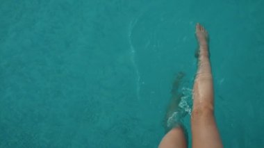 Dişi bacaklar. Havuzun kenarında oturan kadın..