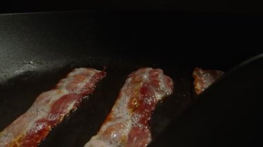 Kızartma tavasındaki pastırma dilimlerinin yakın plan görüntüsü.