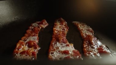 Kızartma tavasındaki pastırma dilimlerinin yakın plan görüntüsü.