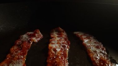 Kızartma tavasındaki pastırma dilimlerinin yakın plan görüntüsü.