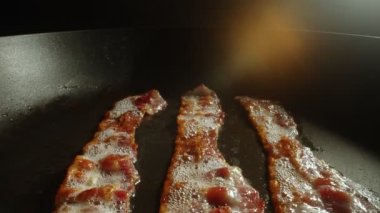 Kızartma tavasındaki pastırma dilimlerinin yakın plan görüntüsü.