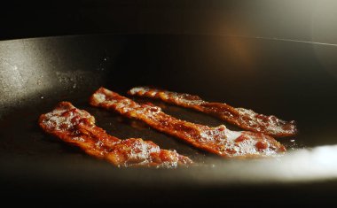 Kızartma tavasındaki pastırma dilimlerinin yakın plan görüntüsü.