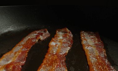 Kızartma tavasındaki pastırma dilimlerinin yakın plan görüntüsü.