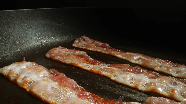 Kızartma tavasındaki pastırma dilimlerinin yakın plan görüntüsü.