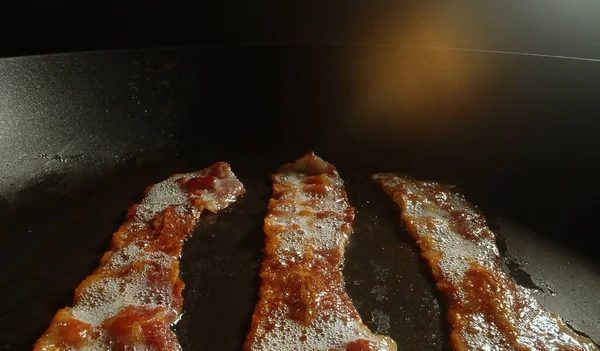 Kızartma tavasındaki pastırma dilimlerinin yakın plan görüntüsü.