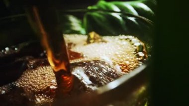 Pouring of cola with ice cubes.