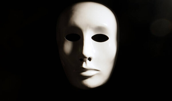 White face mask on dark background.