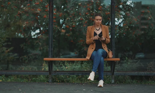 Mujer Con Teléfono Inteligente Está Esperando Autobús Parada Autobús — Foto de Stock