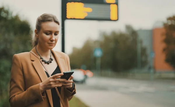 Mujer Con Teléfono Inteligente Está Esperando Autobús Parada Autobús — Foto de Stock