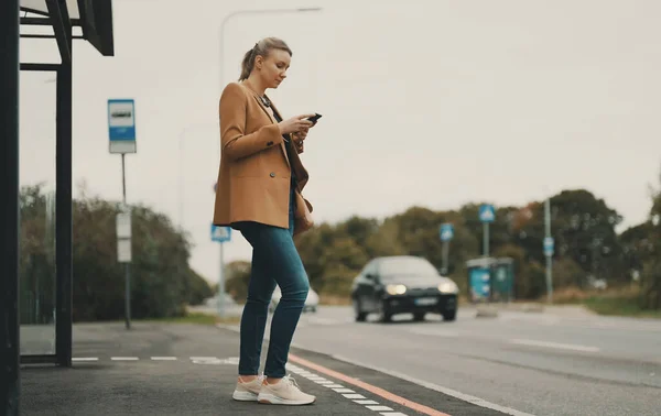 Vrouw Met Smartphone Wacht Bus Bij Bushalte — Stockfoto