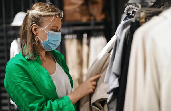 Woman Medical Mask Choosing Clothes Outlet Store — Stock Photo, Image