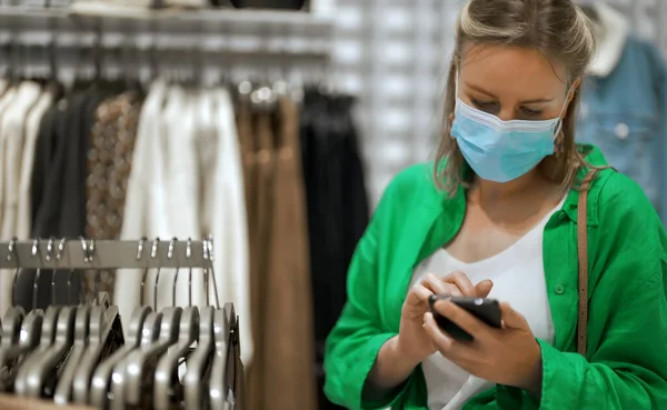 Woman Medical Mask Choosing Clothes Outlet Store — Stock Photo, Image