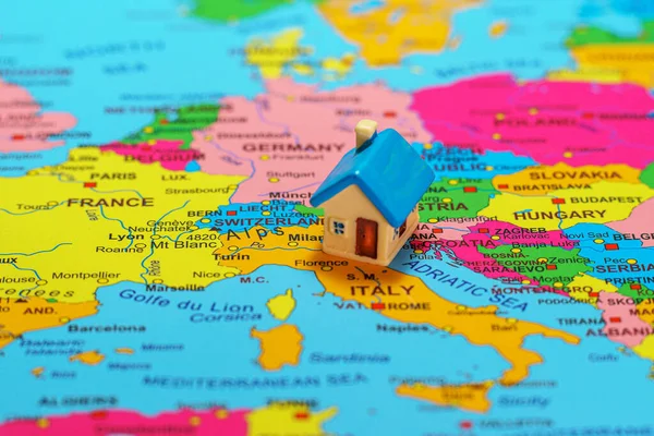 Small toy house on the map of Italy.