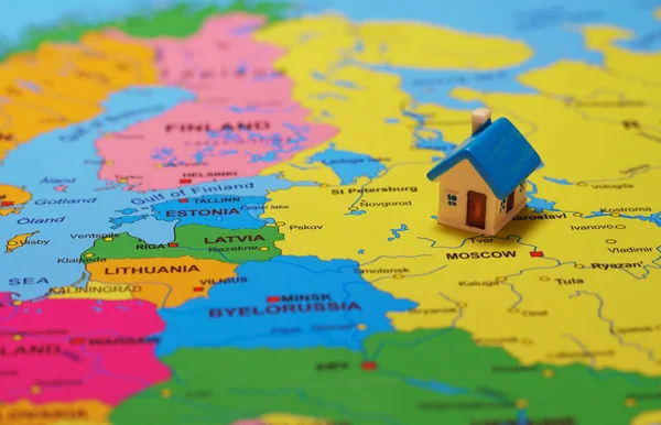 Small toy house on the map of Russia.