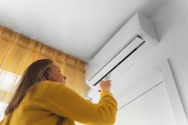 Uzaktan kumanda Klima havalandırma amaçlı tutan kadın.