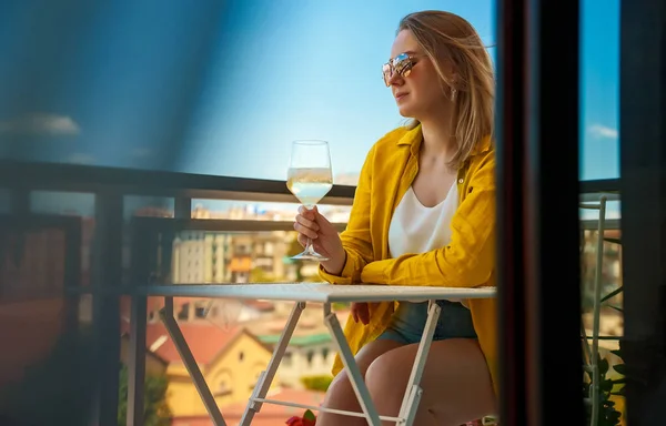 喝白葡萄酒的女人在阳台上度假很愉快 — 图库照片