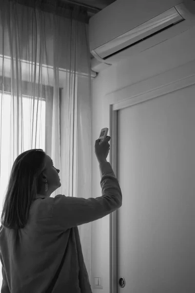 Woman Holding Remote Control Aimed Air Conditioner Black White — Stockfoto