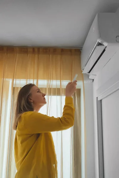 Vrouw Met Afstandsbediening Gericht Air Conditioner — Stockfoto