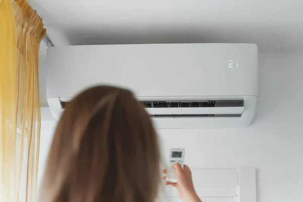 Vrouw Met Afstandsbediening Gericht Air Conditioner — Stockfoto