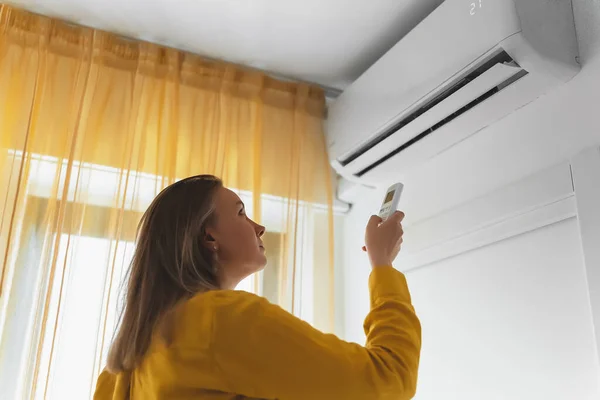 Vrouw Met Afstandsbediening Gericht Air Conditioner — Stockfoto