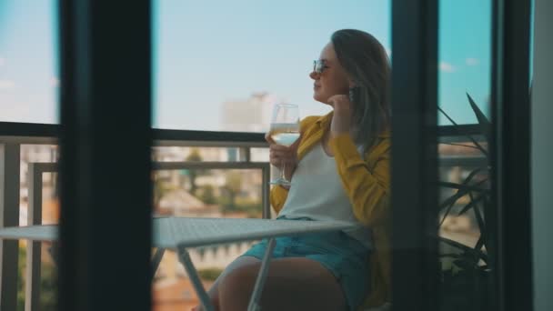 喝白葡萄酒的女人在阳台上度假很愉快 — 图库视频影像