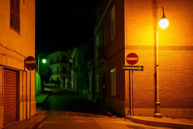 Sarı ve yeşil ışıklı gece sokağı.