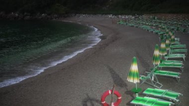 Sassolini sahilinde güneş pansiyonları ve şemsiyeler.