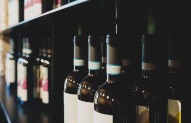 Şaraphanenin tat odasında çeşitli şişelerle raflar..