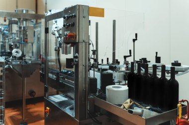 Şarap fabrikasında şişe etiketleme için otomatik hat.