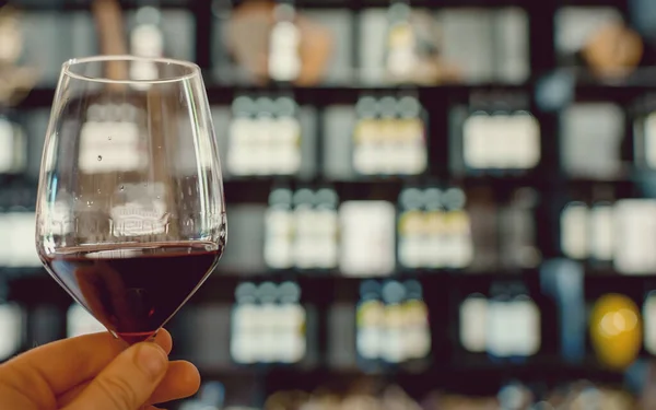 Man Hand Holds Glass Red Wine Background Bottles — Stock Photo, Image