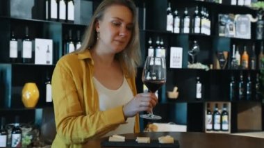 Kadın şaraphanede kırmızı şarap tadıyor..