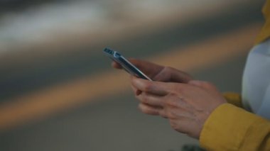 Woman is looking at the news in the smartphone.
