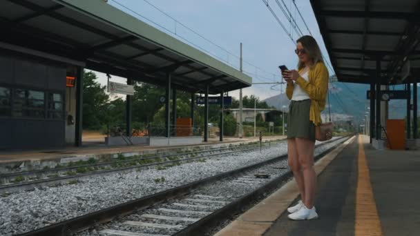 Kobieta Smartfonem Czeka Pociąg — Wideo stockowe