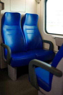 Modern bir elektrikli trende mavi koltuklar.