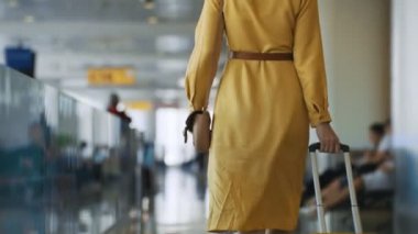 Woman walking in airport terminal. Back view.