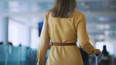 Woman walking in airport terminal. Back view.