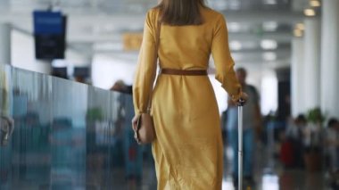 Woman walking in airport terminal. Back view.