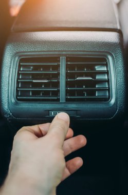 Man adjusting air conditioner inside the car.