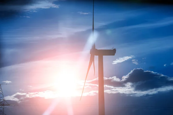 Wind turbine on the sunset. Blue energy.