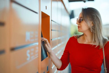 Kadın otomatik otomatik otomatik otomatik servis terminalinden postaları alıyor..