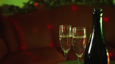 Bottle of champagne and two glasses in night club.