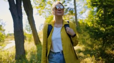 Woman tourist with backpack exploring forest.