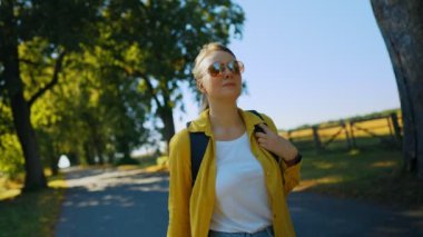 Woman tourist with backpack walking in the countryside.