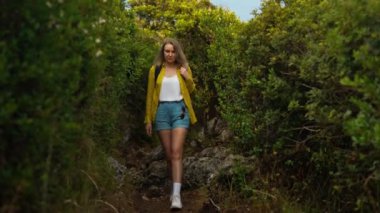 Woman tourist with backpack walking in deep forest.